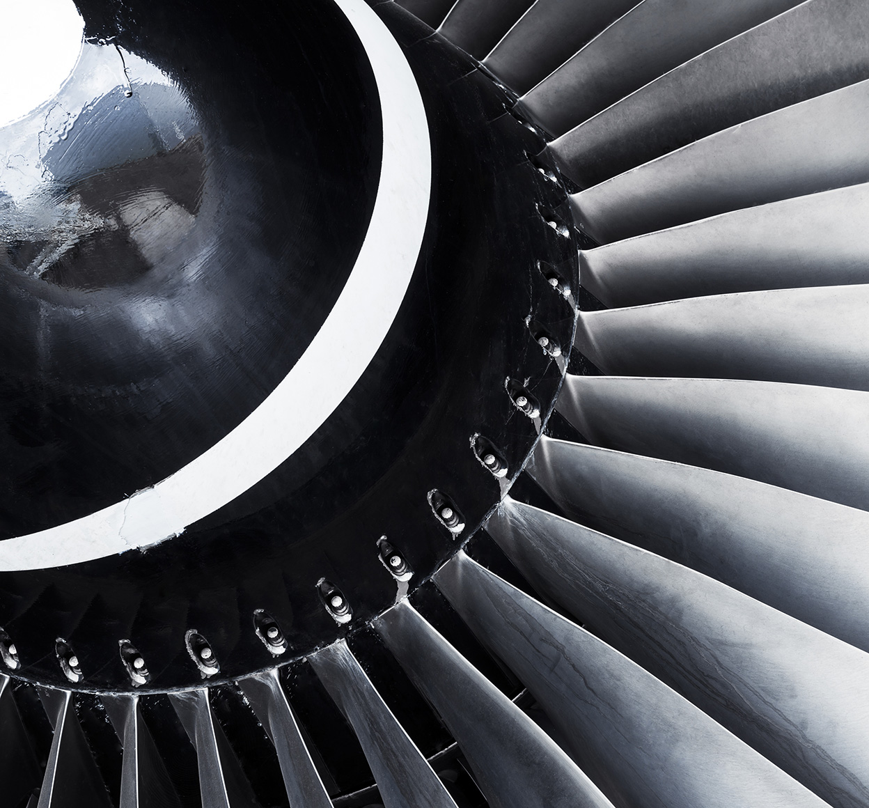A close-up of a jet engine turbine in monochrome colors is a reminder of the power, complexity, and engineering marvel of flight.