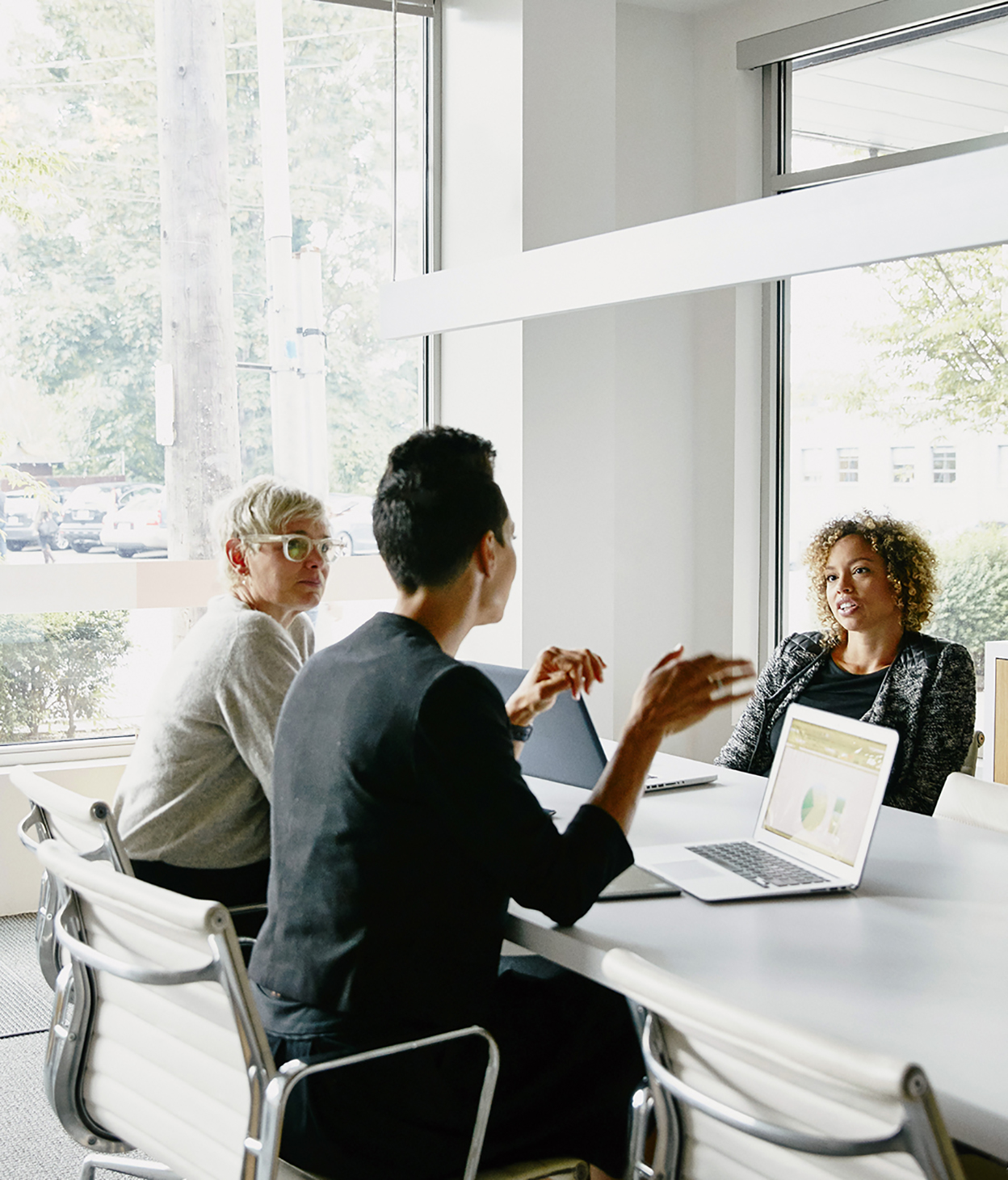 Businesswoman presenting project ideas to colleagues at conference table in office 
